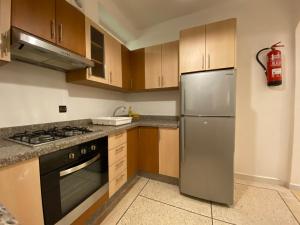 塔鲁丹特Appartement coeur de médina的厨房配有木制橱柜和不锈钢冰箱。