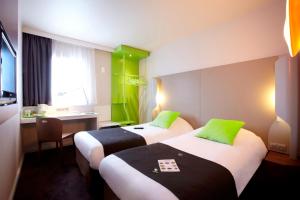 里尔里尔欧洲里尔钟楼酒店的绿意盎然的酒店客房内的两张床