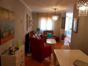 加的斯APARTAMENTO CORTADURA BEACH的客厅配有红色的沙发和椅子