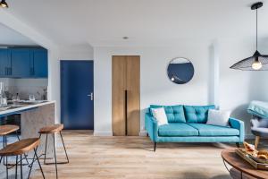 圣马洛Le Cap Cézembre - Intra-Muros Saint-Malo的一间带蓝色沙发的客厅和一间厨房