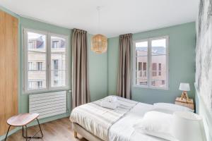 圣马洛Le Cap Cézembre - Intra-Muros Saint-Malo的一间卧室设有一张床和两个窗户。