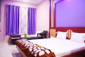 德奥加尔Hotel Shree Hari的一间卧室配有一张床和紫色窗帘