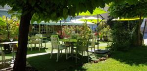 圣热涅-多尔特金狮酒店的花园内摆放着桌椅和遮阳伞