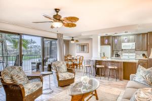 利胡埃Kauai Beach Villas D10的客厅以及带沙发和椅子的厨房。