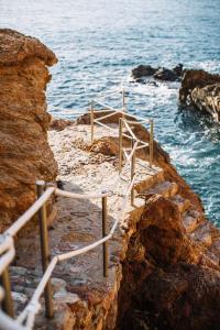 巴古尔Apartaments Cap Sa Sal的靠近海洋的岩石上的楼梯
