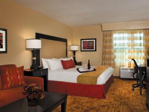 布兰森The Branson Hillside Hotel的酒店客房配有一张床、一张桌子和一把椅子。
