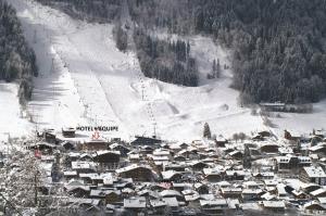 莫尔济讷Hotel L'Equipe的雪中的一个小镇,有滑雪场
