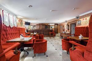克拉斯诺达尔布里斯托尔酒店的餐厅设有红色的隔间和桌椅
