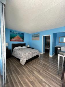 英格尔伍德LA Adventurer Hotel的一间卧室设有蓝色的墙壁、一张床和钢琴