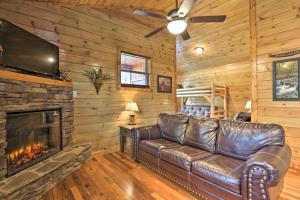 鸽子谷Rustic Pigeon Forge Cabin with Hot Tub Near Town!的客厅设有真皮沙发,配有壁炉