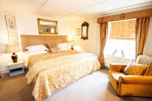 Eglingham坦刻维尔阿姆斯酒店的卧室配有床、椅子和窗户。