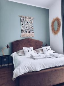 别尔斯克-比亚拉Rost Apartments的配有白色床单和枕头的床铺,带修字器