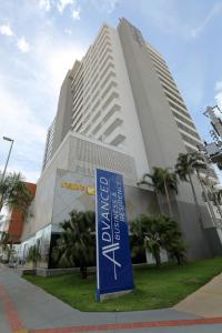 库亚巴Advanced Hotel & Flats Cuiabá的前面有蓝色标志的建筑