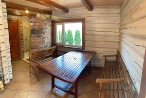 维尔纽斯Rustic private Cabin in woods w/ Sauna & Pool的窗户客房内的木桌和长凳