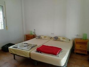 AlmogíaBelvilla by OYO Casa de Aguila的一间卧室配有一张带红色毛巾的床