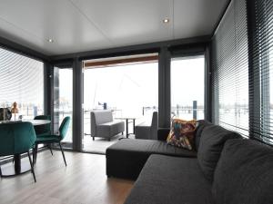 福伦丹Beautiful Houseboat in the harbour of Volendam near Centre的带沙发、桌子和窗户的客厅