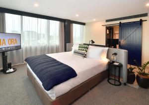 奥克兰Sudima Auckland City的一间卧室配有一张大床和电视