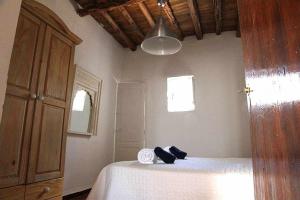 圣卡洛斯Agroturismo Casa Morna Ibiza的一间卧室配有一张床,床上有毛巾