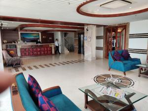 瓦拉纳西Comfort Inn Benares的客厅配有蓝色的椅子和桌子