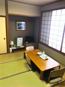 福岛吨详福岛旅馆的客房设有木桌、椅子和窗户。