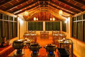 ThirunelliAgraharam Resorts的配有桌椅、锅和平底锅的房间