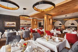 巴特维塞Hotel Alpenhof的一间设有白色桌子和红色椅子的餐厅