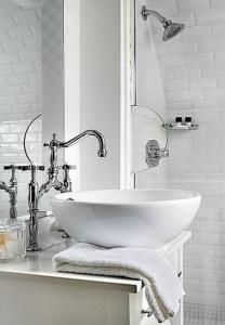 埃克塞特The Exeter Inn的白色的浴室设有水槽和镜子