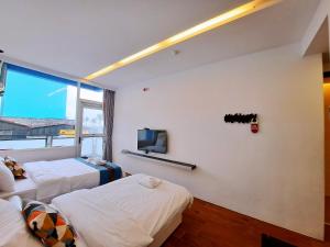 花莲市海芸旅人窝的客房设有两张床和一台墙上的电视。
