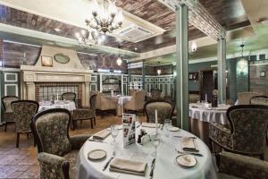布良斯克大都市酒店的一间带桌椅和壁炉的餐厅