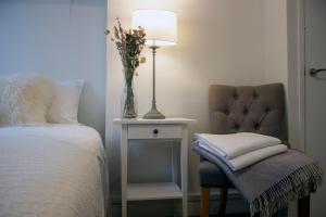 霍利伍德Downshire Haven的一间卧室配有一张床和一把带花瓶的椅子