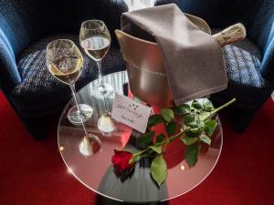 斯莱纳肯斯莱纳肯贝斯特韦斯特酒店的一张桌子,上面放着两杯酒和一束鲜花