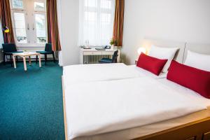 美因茨Erbacher Hof, Bistum Mainz的卧室配有带红色枕头的大型白色床