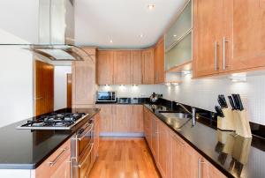 爱丁堡Britannia Penthouse的厨房配有木制橱柜和不锈钢用具