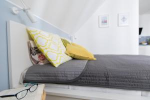 尼彻兹Apartamenty Pomona的一张带黄色枕头的床和一张桌子上的书
