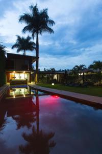 坎帕拉Humura Resorts的一座带棕榈树游泳池的房子