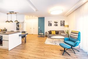 格拉茨VIVA Apartments的厨房以及带蓝椅的起居室