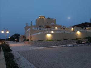 卡武埃鲁Quinta Nova Vale Del Rey的一座白色的大建筑,旁边灯火通明