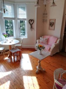 PeterculterFurain的客厅配有粉红色的沙发和桌子