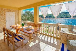 日列岛House Petra的一间带桌椅和窗户的用餐室