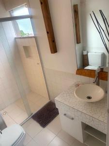 巴拉奈里奥-坎布里乌Estaleiro Casa Hotel的带淋浴、盥洗盆和卫生间的浴室