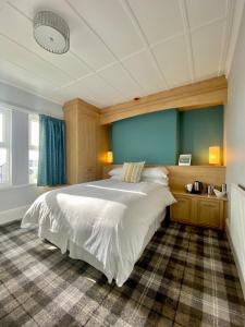 锡斯凯尔Cumbrian Lodge的卧室配有一张白色大床和蓝色的墙壁