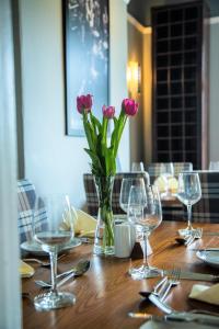 锡斯凯尔Cumbrian Lodge的花瓶上摆放着粉红色花的桌子