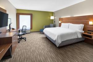 斯泰茨伯勒Holiday Inn Express Statesboro, an IHG Hotel的配有一张床和一台平面电视的酒店客房