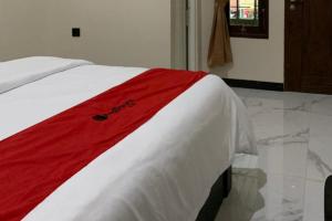 PatiRedDoorz Syariah near Kawasan Simpang Lima Pati的床上有红白毯子