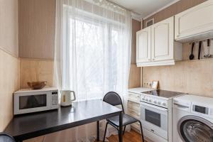 莫斯科Standard Brusnika standart Yaseneva的一间带桌子和微波炉的小厨房