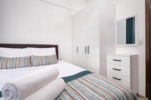 凯麦尔Sayan Apart Hotel的一间白色卧室,配有一张床和一个梳妆台