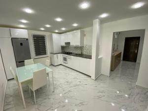 特尔古穆列什Concept Apartments 3 Camere的一间白色的大厨房,配有桌椅