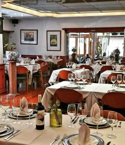 科尔多瓦HOTEL CASTELAR CORDOBA的用餐室配有白色桌椅和酒杯