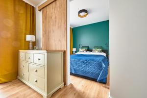 奥尔什丁Apartament Księżycowy的一间卧室设有一张床和蓝色的墙壁