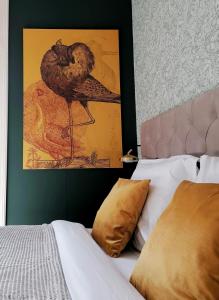 斯滕韦克B&B De Stadssingel的鸟坐在床边的墙上